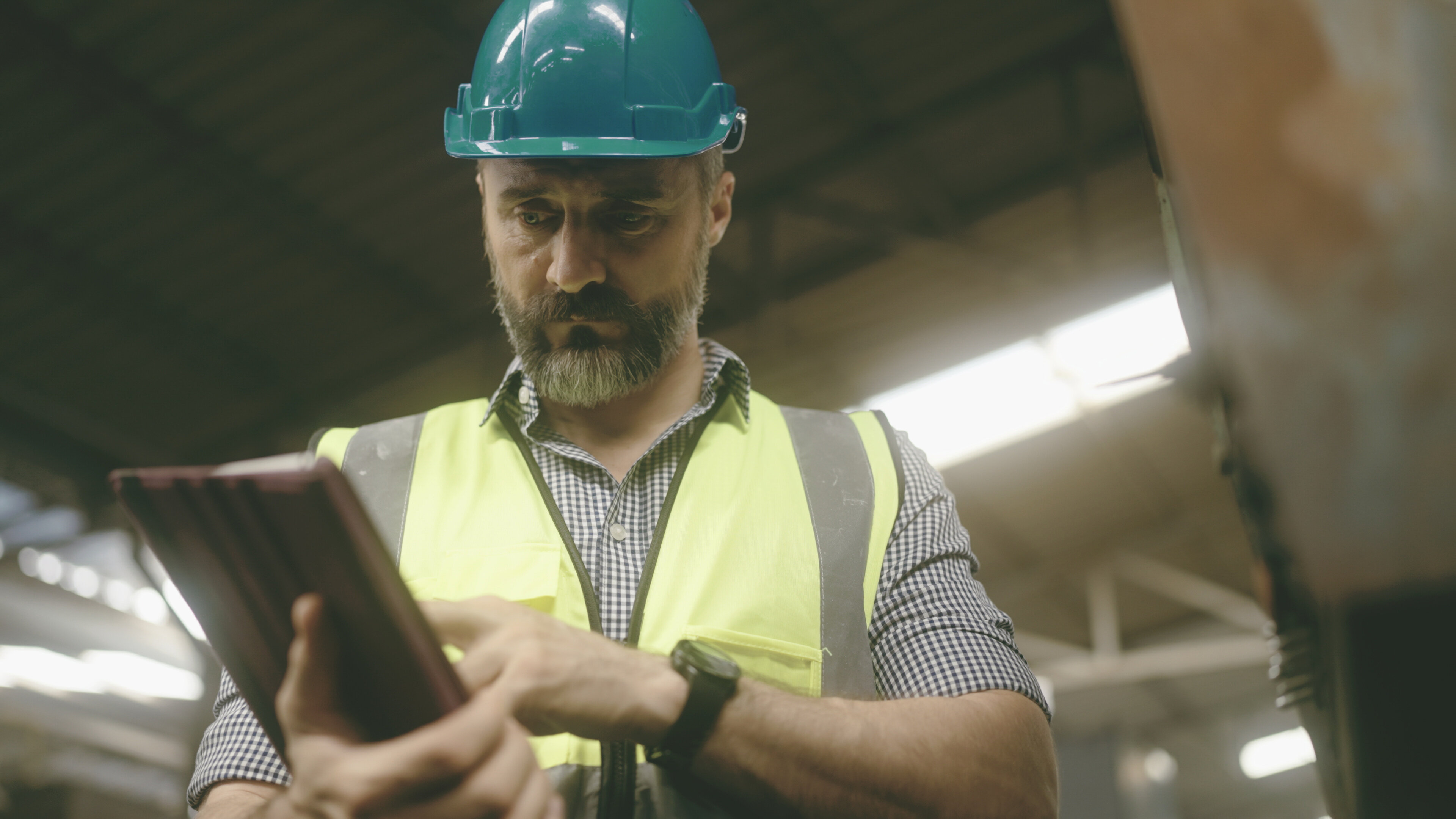 Image of maintenance worker looking at MaintainX application on tablet device